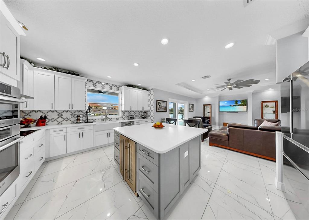 901 Capriccio Lane Apollo Beach, FL 33572 - Photo 19 of 83 a kitchen with a stove top oven and white cabinets