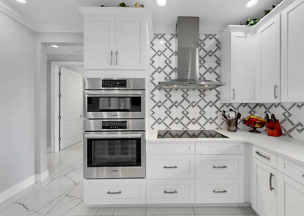 901 Capriccio Lane Apollo Beach, FL 33572 - Photo 21 of 83 a kitchen with white cabinets and stainless steel appliances