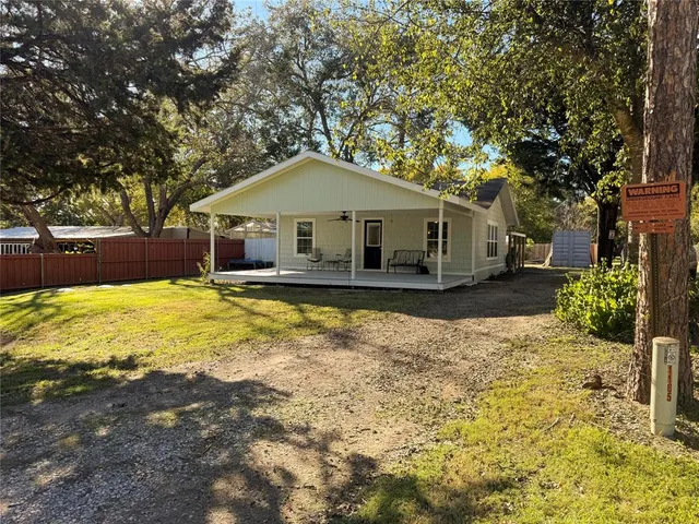 a front view of a house with a yard covered with snow and trees