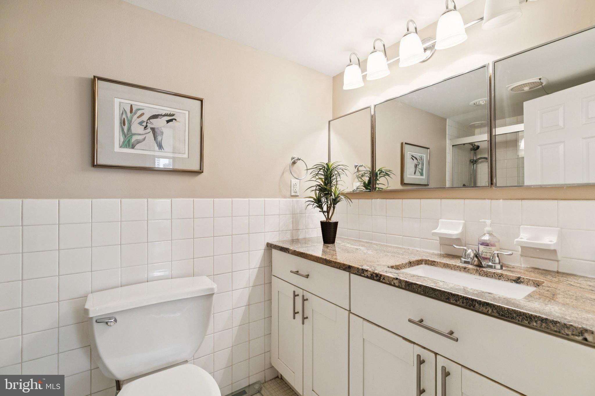 1919 Chestnut Street, Unit 707 Philadelphia, PA 19103 - Photo 22 of 36 a bathroom with a toilet sink and mirror