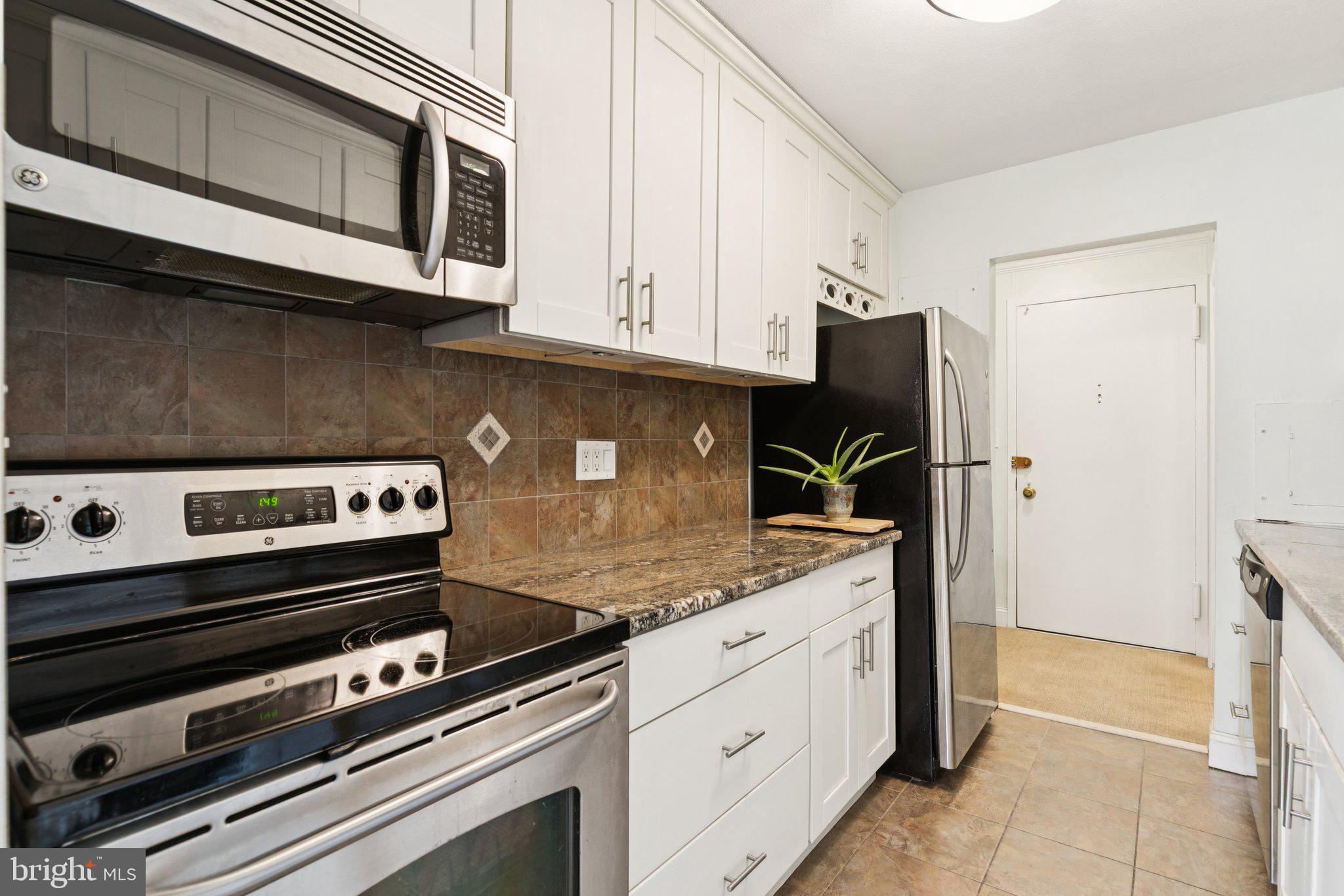 1919 Chestnut Street, Unit 707 Philadelphia, PA 19103 - Photo 8 of 36 a kitchen with stainless steel appliances granite countertop a stove and a microwave