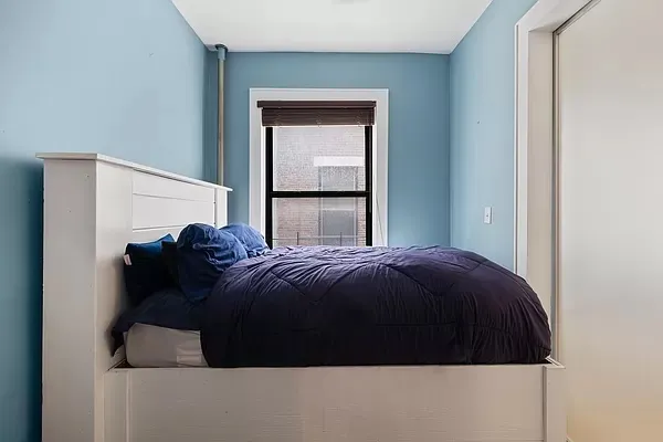 a bed sitting in a bedroom next to a window