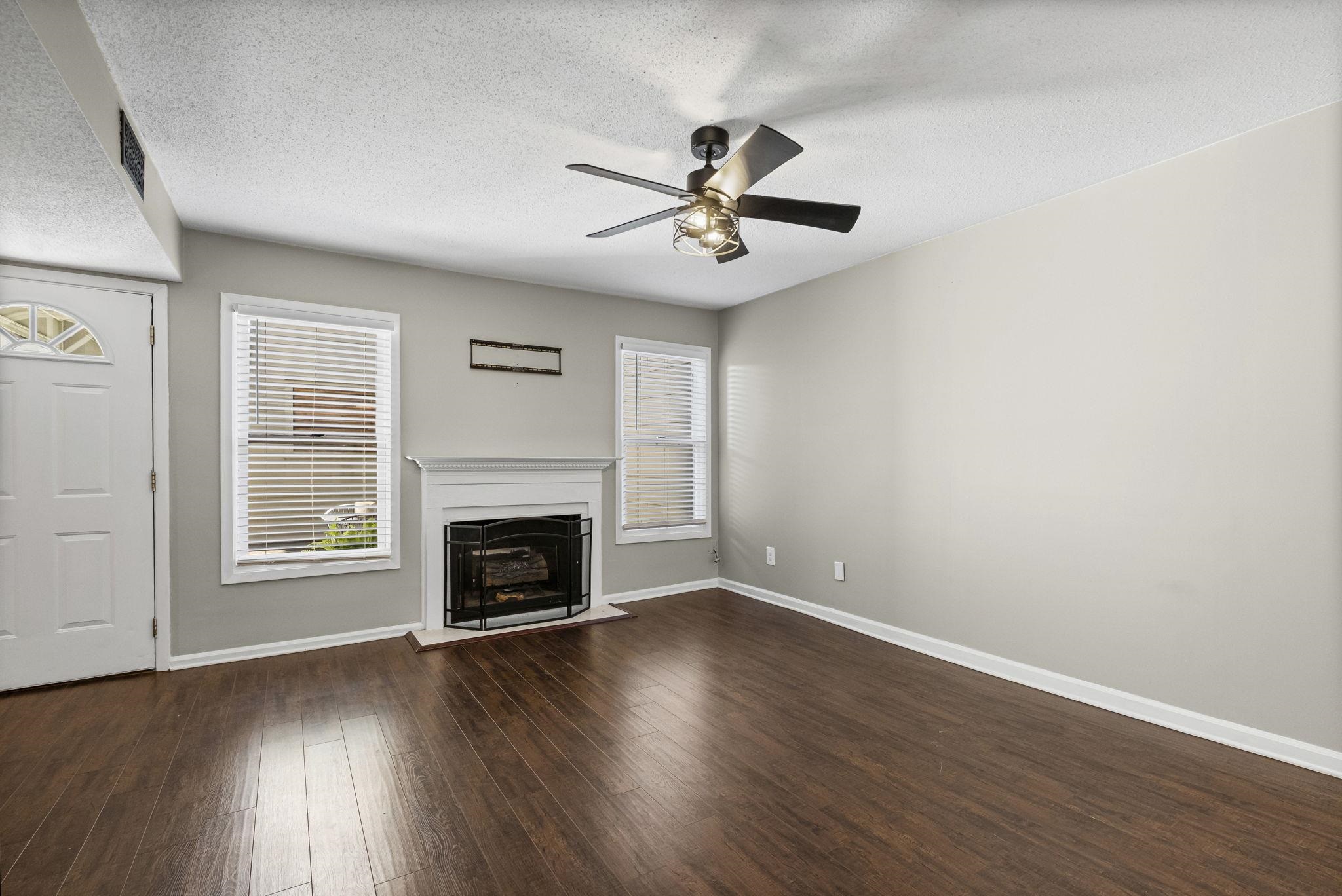 1942 Allenby Road Germantown, TN 38139 - Photo 15 of 34 a view of an empty room with wooden floor fireplace and a window