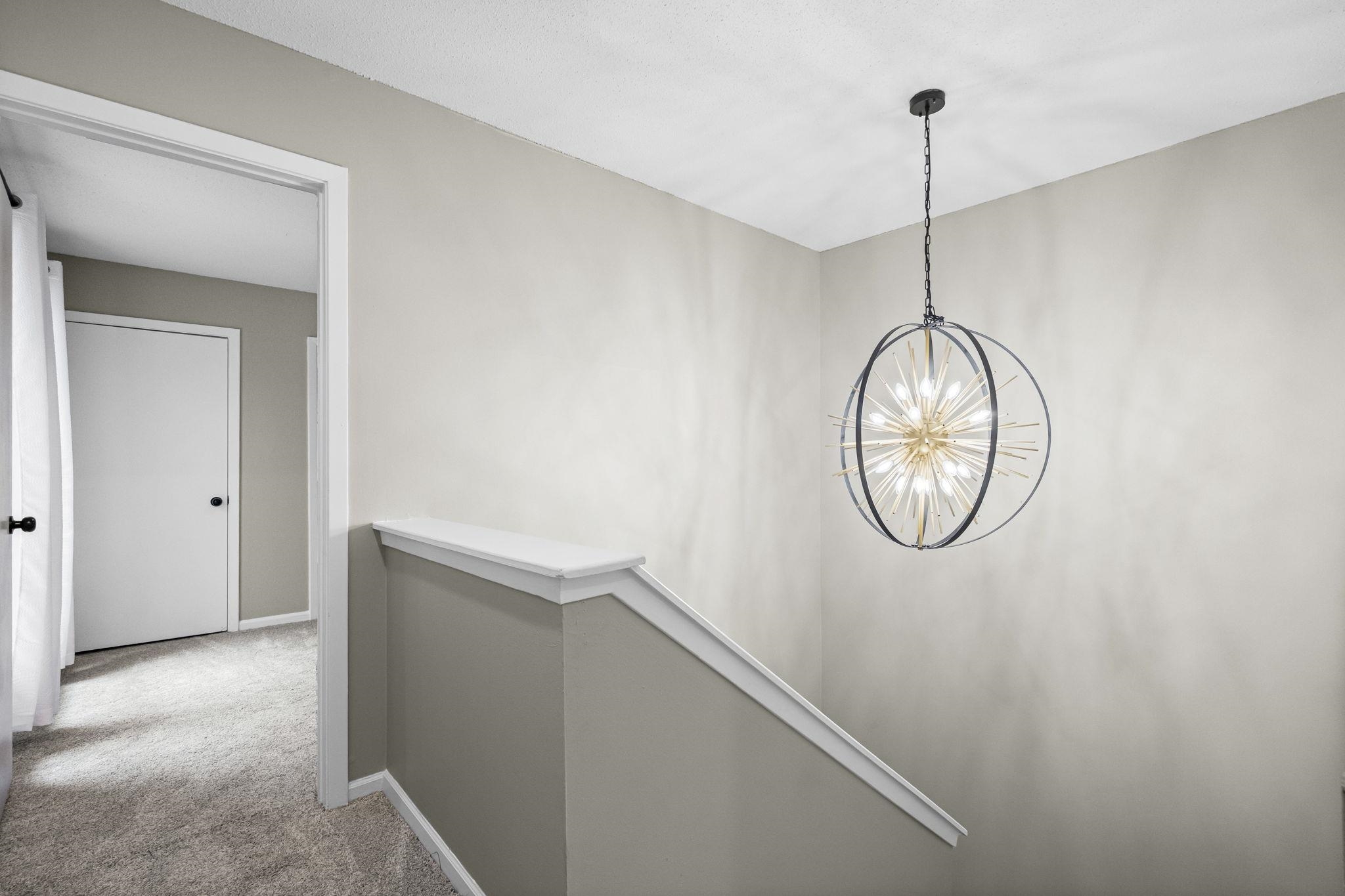 1942 Allenby Road Germantown, TN 38139 - Photo 19 of 34 Corridor featuring light colored carpet and a chandelier