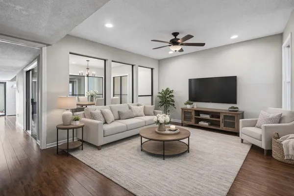 a view of an empty room with wooden floor and windows