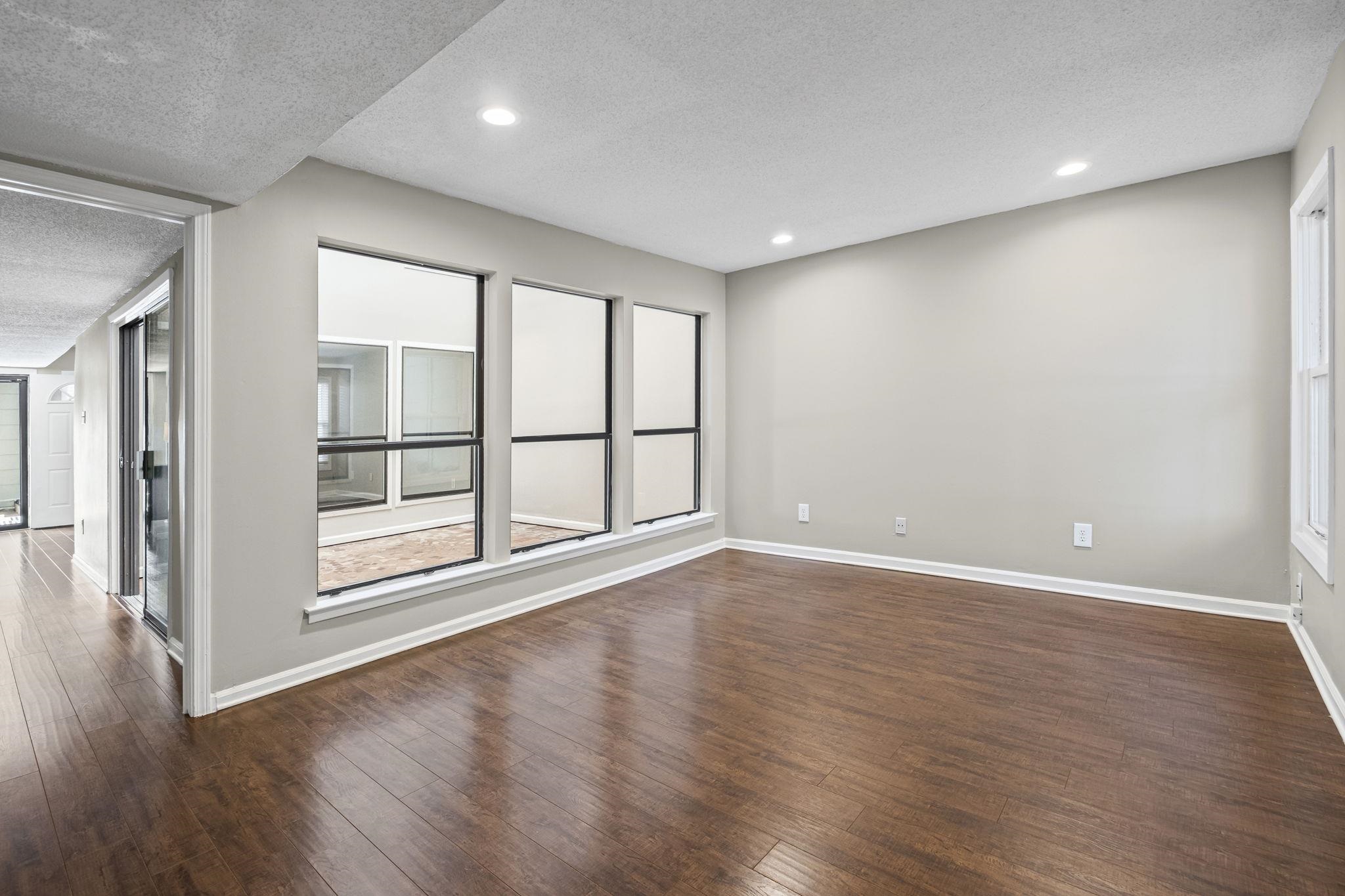 1942 Allenby Road Germantown, TN 38139 - Photo 3 of 34 a view of an empty room with wooden floor and windows