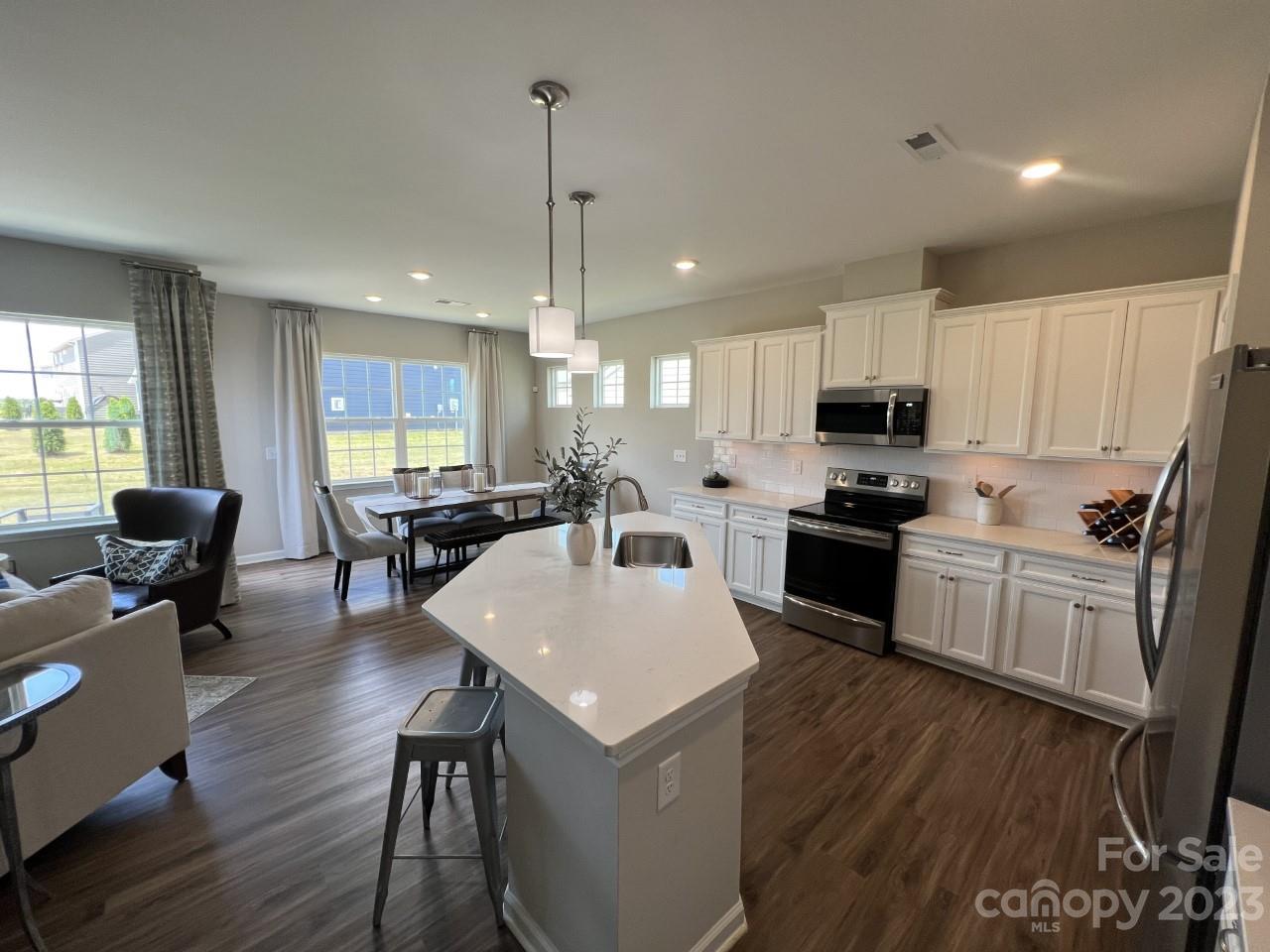 1612 Corwin Bend Road, Unit 2 Tega Cay, SC 29708 - Photo 2 of 7 a kitchen with a refrigerator a stove top oven a sink dishwasher a dining table and chairs with wooden floor