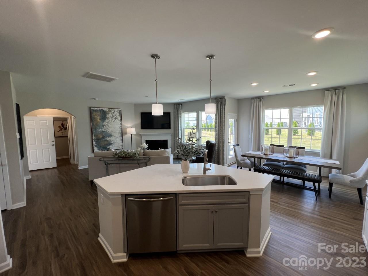 1612 Corwin Bend Road, Unit 2 Tega Cay, SC 29708 - Photo 3 of 7 a room with stainless steel appliances kitchen island granite countertop a sink a dining table and chairs with wooden floor