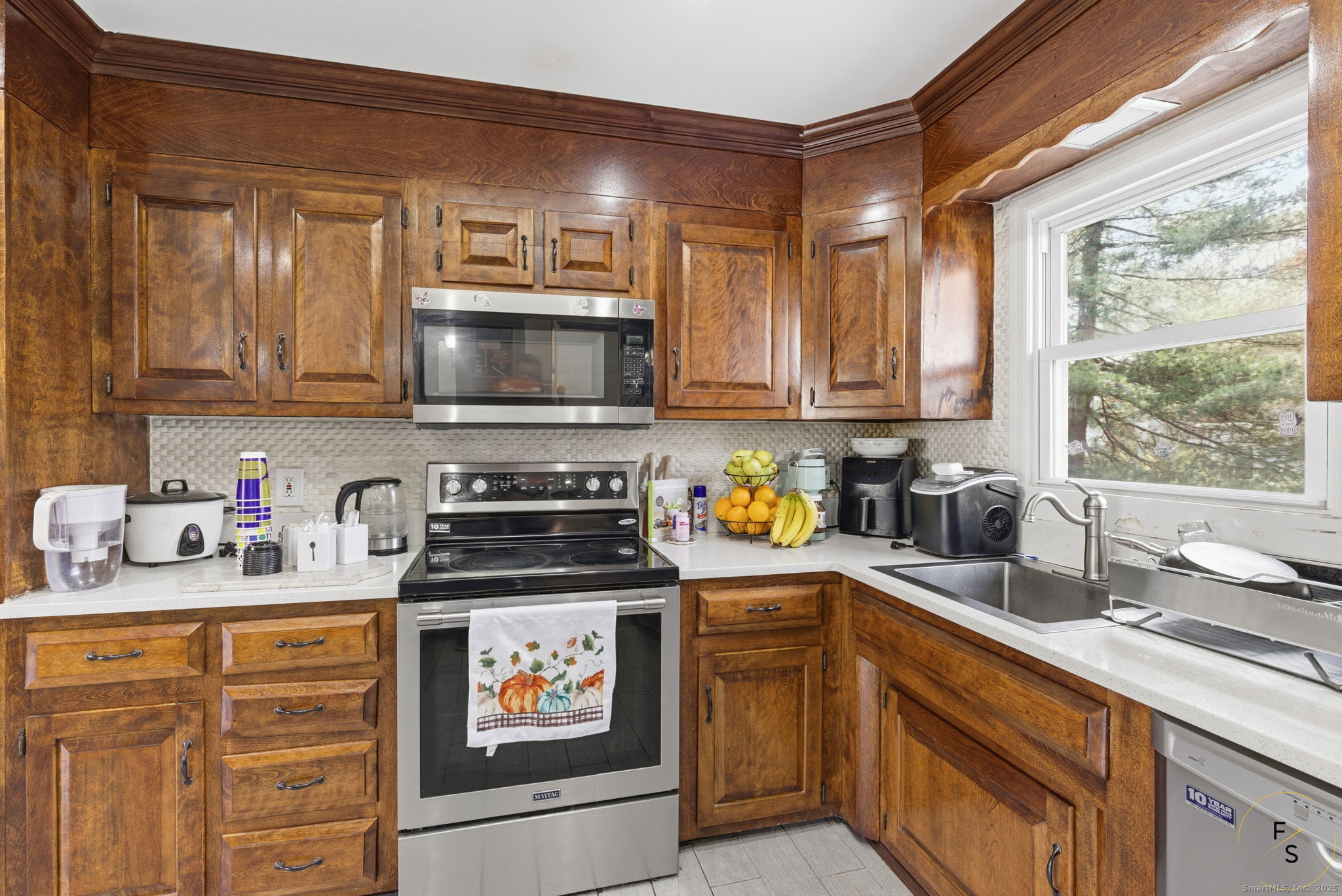 29 Priscilla Road Norwalk, CT 06850 - Photo 12 of 40 a kitchen with stainless steel appliances a stove a sink a refrigerator a microwave a cabinets and wooden floor
