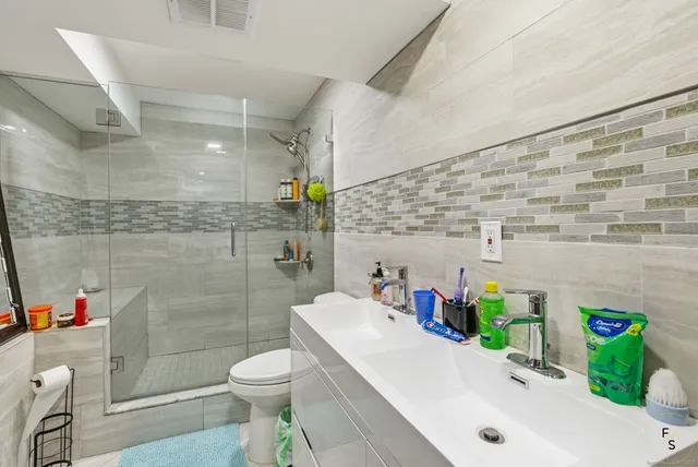 a bathroom with a sink a toilet and shower