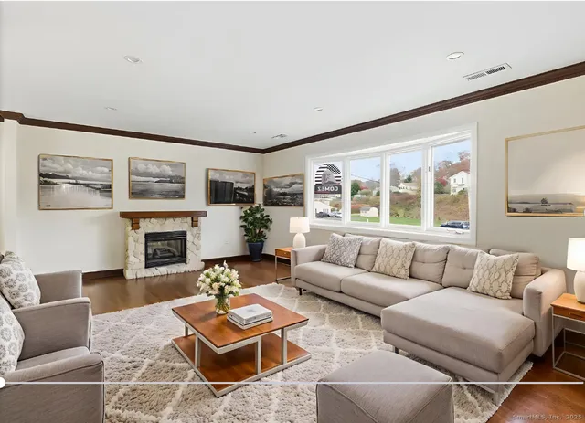 a living room with furniture a fireplace and a large window