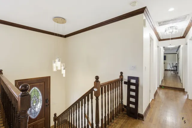 a view of a hallway with wooden floor and stairs