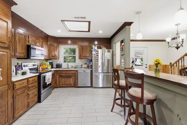 a kitchen with granite countertop a counter space stainless steel appliances cabinets and furniture