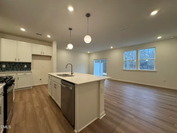 a kitchen with stove and wooden floor