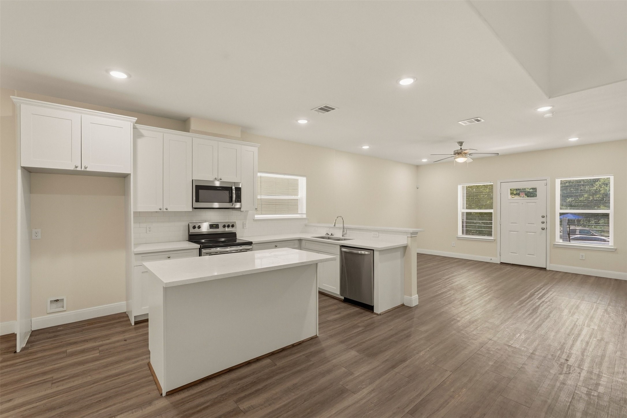 2218 Bringhurst Street, Unit B Houston, TX 77026 - Photo 10 of 25 a kitchen with stainless steel appliances a stove top oven a sink dishwasher and a refrigerator with wooden floor