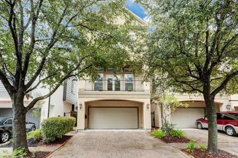 a front view of a house with yard and tree