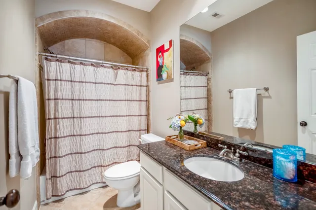 a backyard of a house with plants and trees with wooden fence