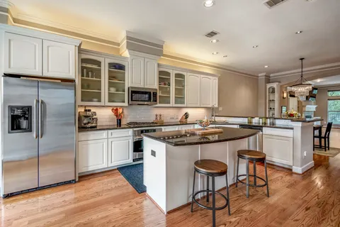 a kitchen with stainless steel appliances granite countertop a stove a sink and a refrigerator