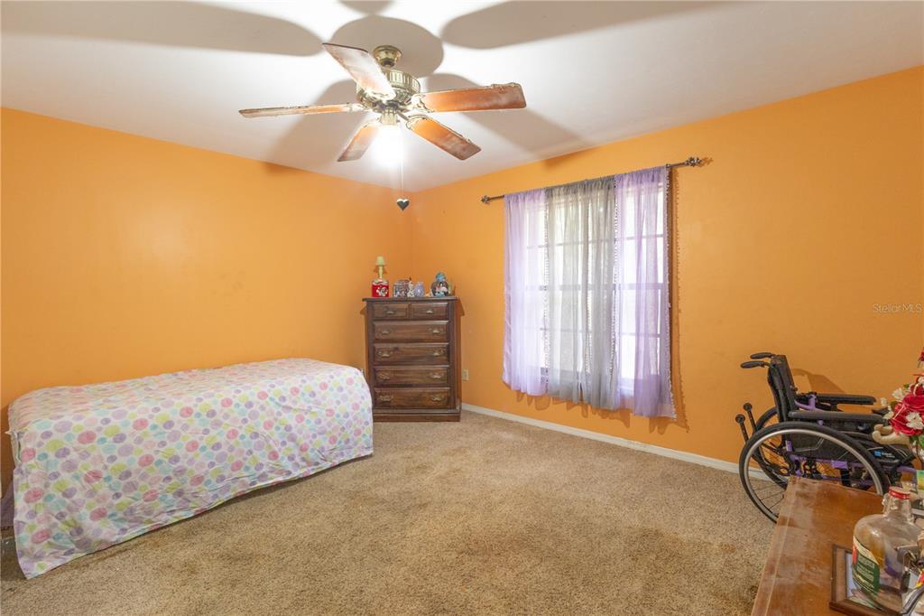 2641 Southeast 45th Street Ocala, FL 34480 - Photo 21 of 36 a bedroom with a bed and a chandelier