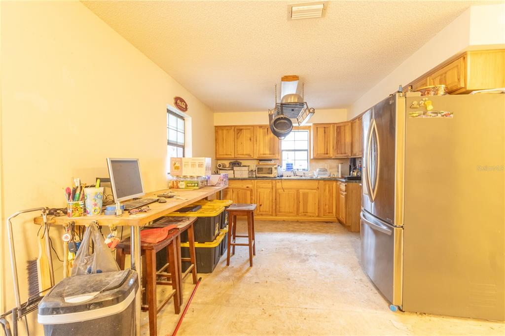 2641 Southeast 45th Street Ocala, FL 34480 - Photo 25 of 36 a kitchen with stainless steel appliances kitchen island granite countertop a refrigerator and cabinets