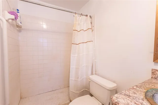 a bathroom with a shower a toilet and sink