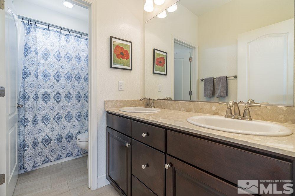 2180 Blue Oaks Drive Reno, NV 89521 - Photo 19 of 27 a bathroom with a granite countertop sink a mirror and a shower