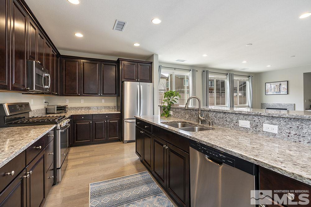 2180 Blue Oaks Drive Reno, NV 89521 - Photo 8 of 27 a kitchen with stainless steel appliances granite countertop a sink stove and refrigerator