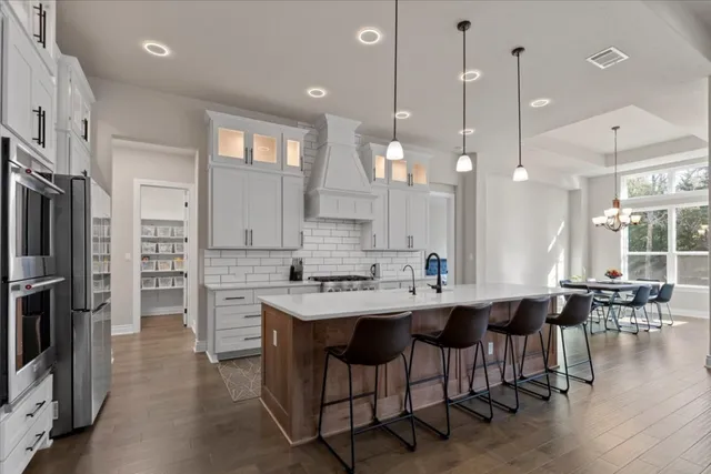 a kitchen with a dining table chairs sink and cabinets