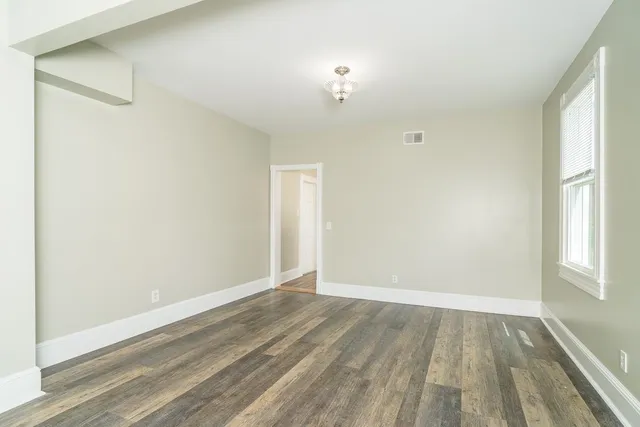 a view of a livingroom with a fireplace wooden floor and windows