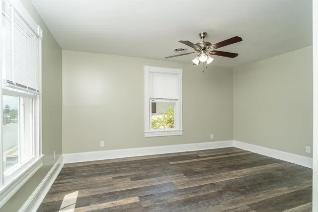 a view of empty room with window and ceiling fan