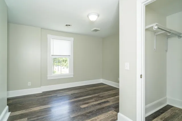 an empty room with a bathroom and a window