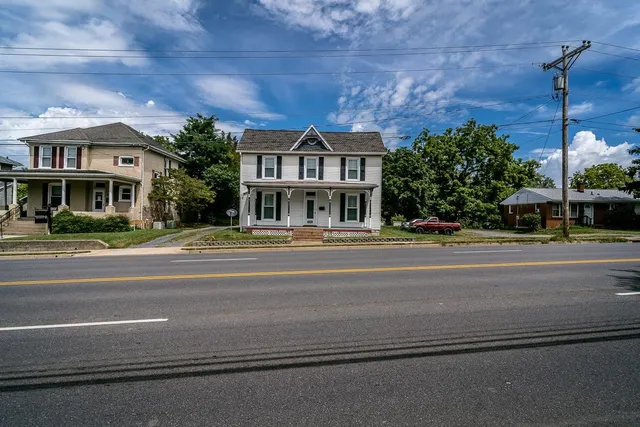 a view of a house with a big yard and large trees