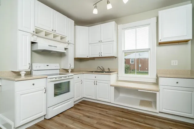 a kitchen with granite countertop white cabinets and white appliances