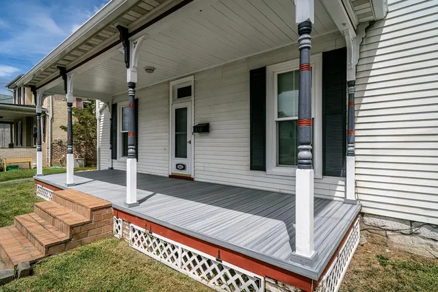a view of a white house with a road and a yard