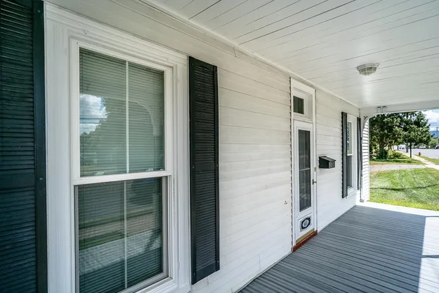 a view of a porch with a door and a yard