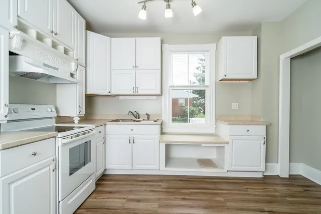 a kitchen with white cabinets and white appliances