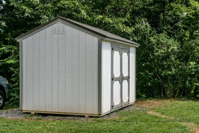 a wooden house with tree in front of it