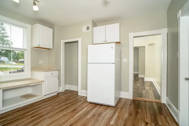 a view of a kitchen with a refrigerator and a stove top oven