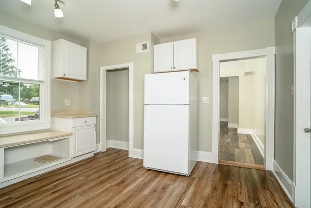 a view of a kitchen with a refrigerator and a stove top oven