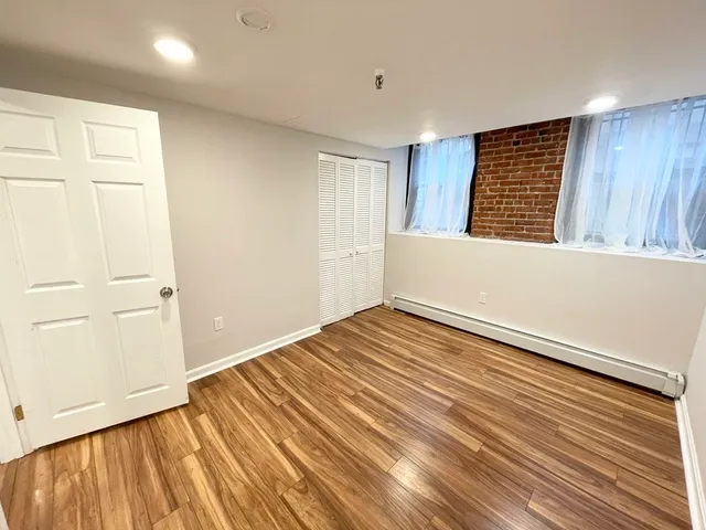 a view of a room with wooden floor and cabinet