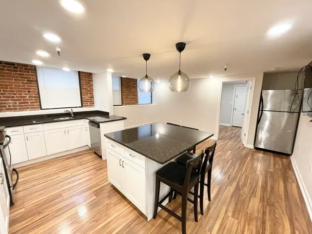 a kitchen with granite countertop a sink a counter space stainless steel appliances and cabinets