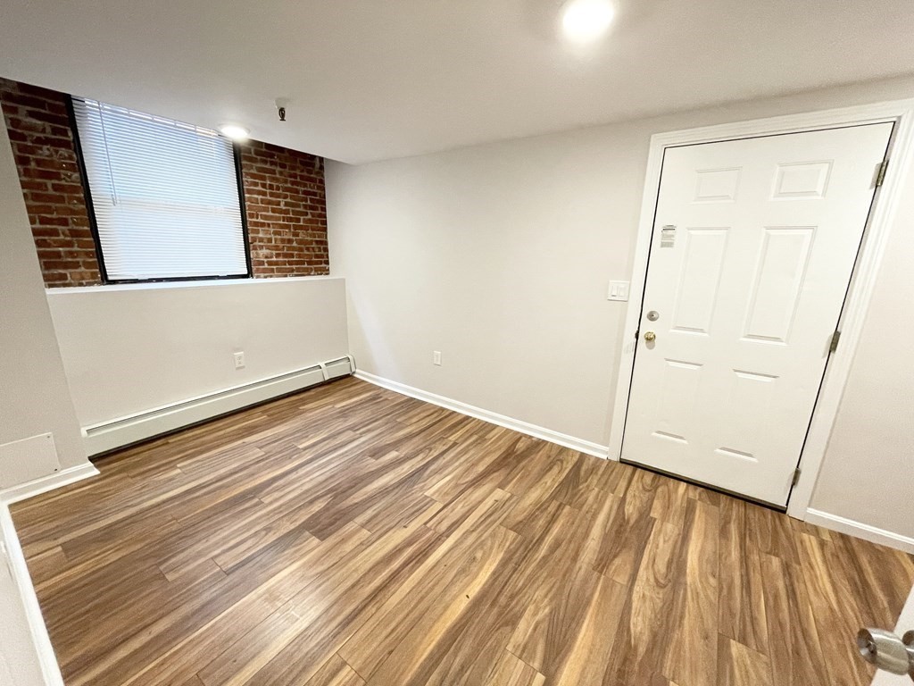 39 Hemenway Street, Unit 26 Boston, MA 02115 - Photo 16 of 27 an empty room with wooden floor and windows