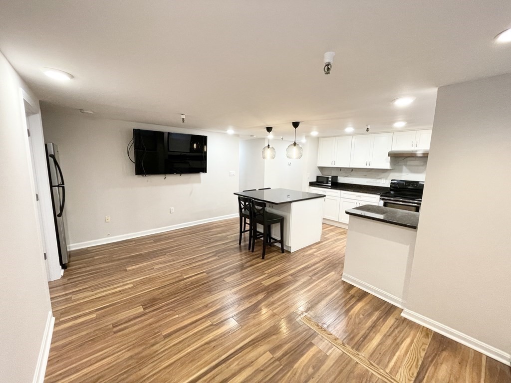 39 Hemenway Street, Unit 26 Boston, MA 02115 - Photo 18 of 27 a kitchen with granite countertop a stove and a wooden floor