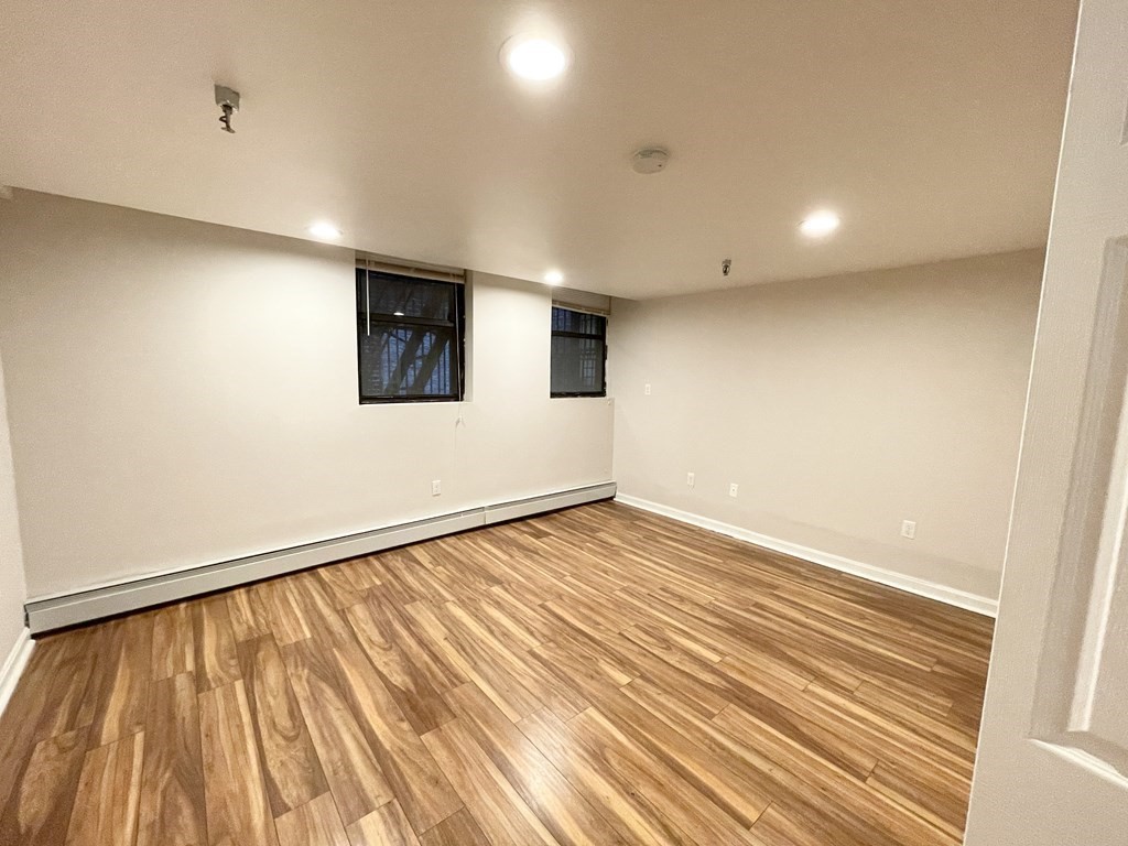 39 Hemenway Street, Unit 26 Boston, MA 02115 - Photo 19 of 27 an empty room with wooden floor and windows