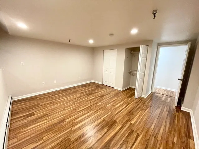 a view of empty room with wooden floor