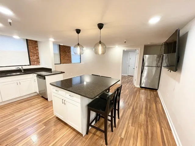 a kitchen with a sink a refrigerator and wooden floor