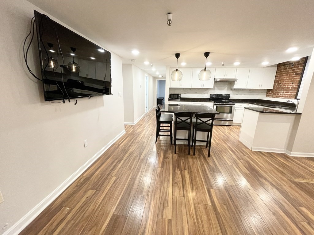 39 Hemenway Street, Unit 26 Boston, MA 02115 - Photo 5 of 27 a kitchen with stainless steel appliances kitchen island granite countertop a stove a sink and a microwave
