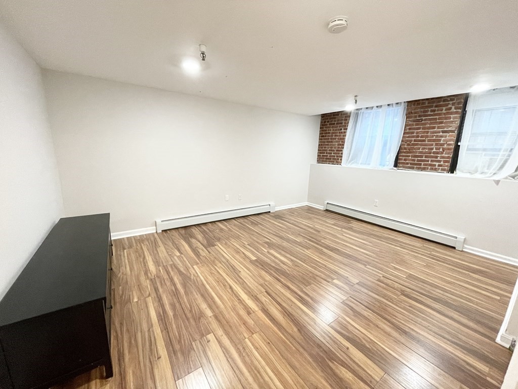 39 Hemenway Street, Unit 26 Boston, MA 02115 - Photo 7 of 27 a view of an empty room with wooden floor