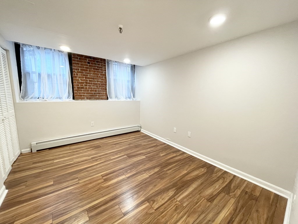 39 Hemenway Street, Unit 26 Boston, MA 02115 - Photo 9 of 27 a view of an empty room with wooden floor and a window