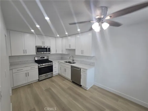 a kitchen with granite countertop cabinets stainless steel appliances and a sink